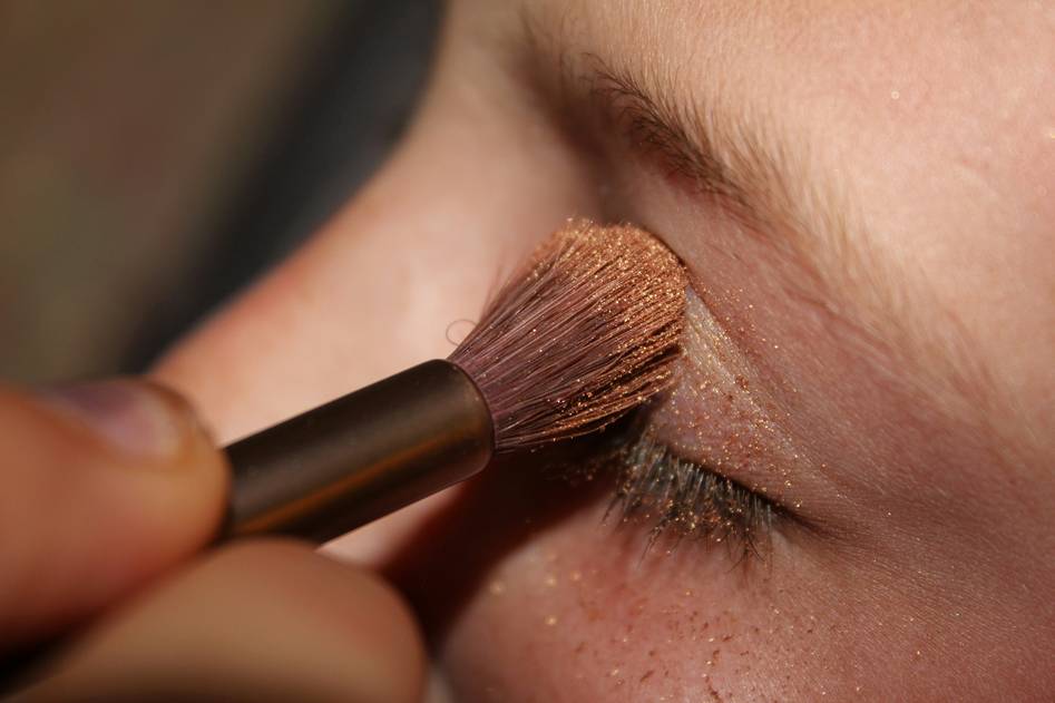 Beauty blogger applying eyebrow tint in soft natural light