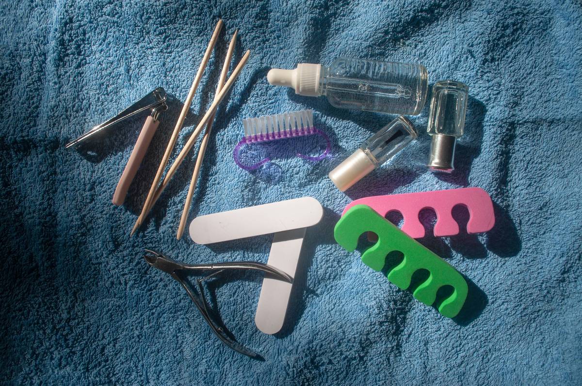 Woman using an eyebrow tinting set at home with brush and mirror